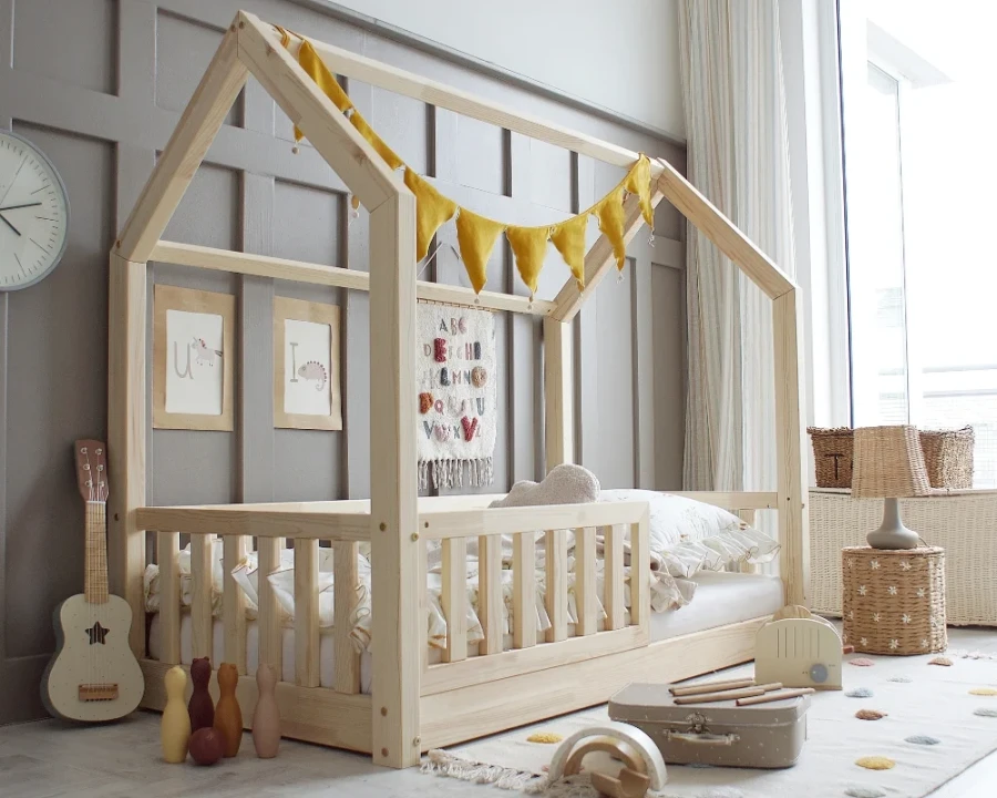Niedriges Hausbett für Kleinkinder aus Holz, ideal für ein Montessori-Kinderzimmer.