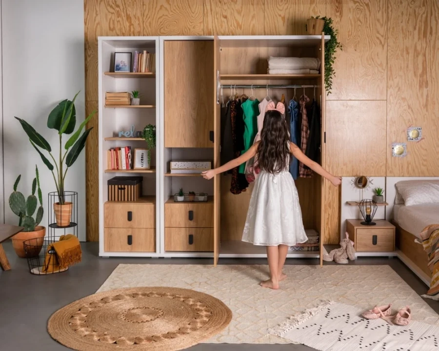 Eingerichtetes Kinderzimmer mit offenem Holz-Kleiderschrank