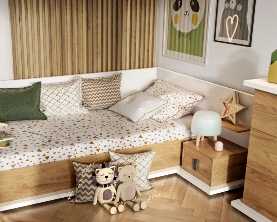 Detailansicht eines Kinderbetts mit gemusterter Bettwäsche, vielen Kissen und Kuscheltieren.