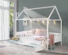 Dekoriertes weißes Hausbett für Kinder mit Lichterkette und gemütlichen Kissen im Schlafzimmer.