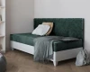 Dunkelgrünes Daybed aus Samt mit weißem Unterbau und dekorativen Kissen.