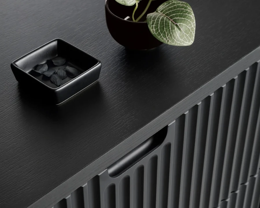 Nahaufnahme der schwarzen Holzstruktur und Griffmulde eines Sideboards mit Rillendesign.