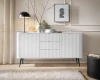 Stilvoll dekoriertes weißes Sideboard in einem hellen, modernen Wohnzimmer.