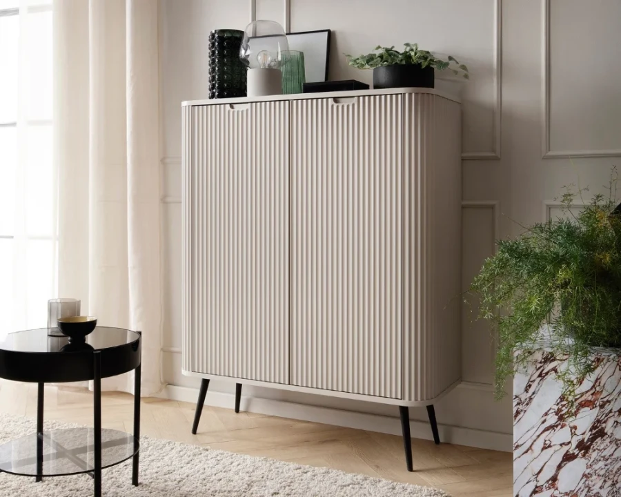Modernes Highboard in Beige mit Rillenstruktur und schwarzen Beinen im Wohnzimmer.