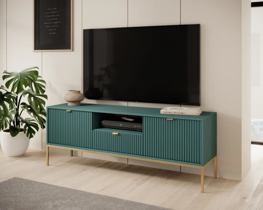 Modernes TV-Lowboard in Petrol mit geriffelter Front und goldenen Füßen im Wohnzimmer.