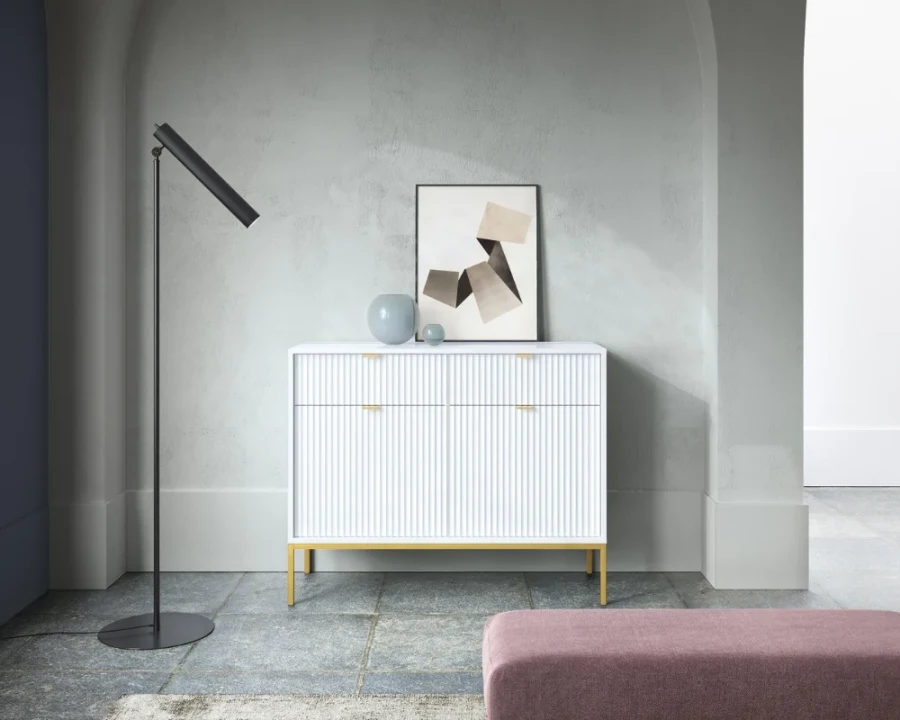 Weißes Sideboard mit geriffelter Front und goldenen Beinen im modernen Wohnzimmer.