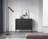 Schwarze Kommode mit vertikalen Rillen und goldenen Griffen im minimalistischen Wohnzimmer.
