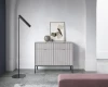 Graue Kommode mit vertikalen Rillen und schwarzen Beinen im minimalistischen Design.