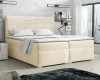 Komfortables Boxspringbett in Beige mit markantem geriffeltem Kopfteil in einem hellen Schlafzimmer.