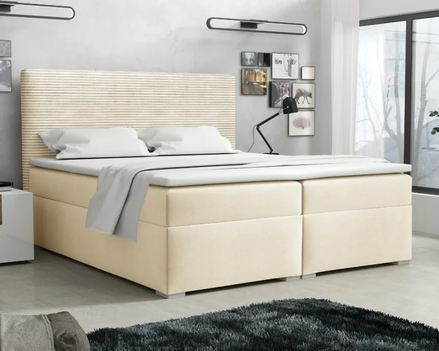 Komfortables Boxspringbett in Beige mit markantem geriffeltem Kopfteil in einem hellen Schlafzimmer.