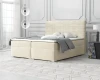 Beiges Boxspringbett mit geriffeltem Kopfteil in modernem, hellen Schlafzimmer.