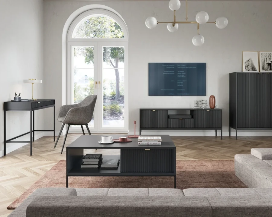 Modernes Wohnzimmer mit schwarzem Couchtisch, TV-Board und Schreibtisch mit schwarzen Beinen.