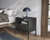 Schwarzer Nachttisch mit geriffelter Schublade, Goldgriff und blauer Lampe im modernen Schlafzimmer.