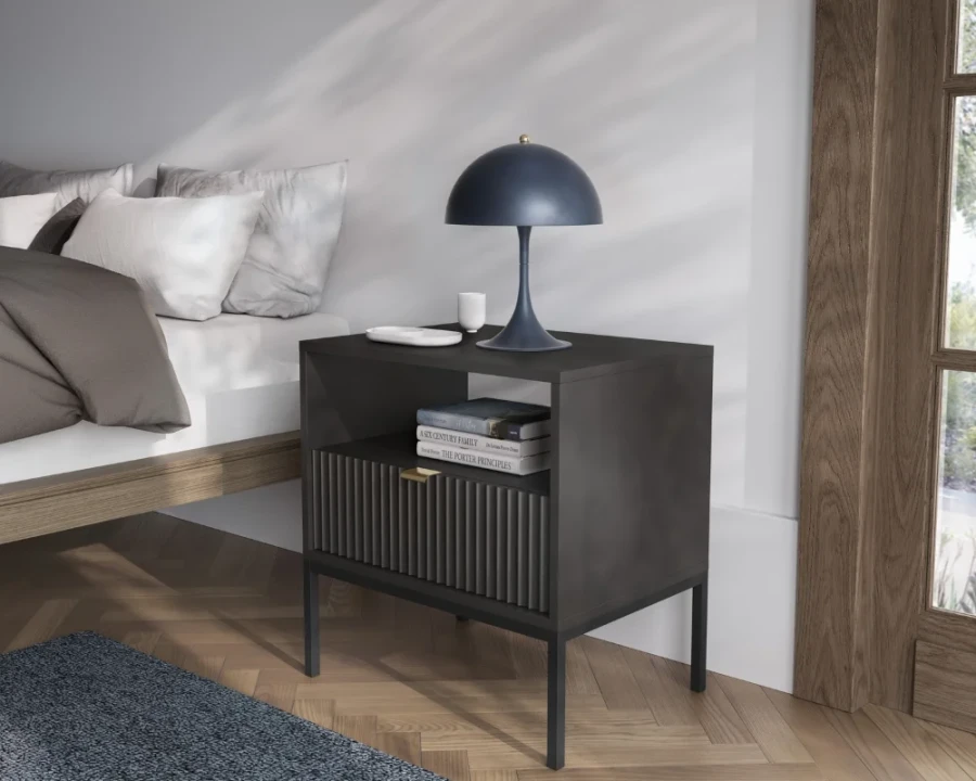 Schwarzer Nachttisch mit geriffelter Schublade, Goldgriff und blauer Lampe im modernen Schlafzimmer.