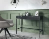 Moderner schwarzer Schreibtisch in grünem Zimmer mit grauem Sessel.