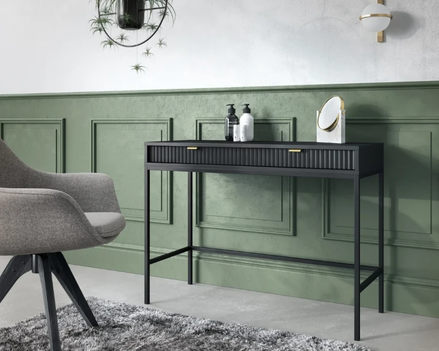 Moderner schwarzer Schreibtisch in grünem Zimmer mit grauem Sessel.