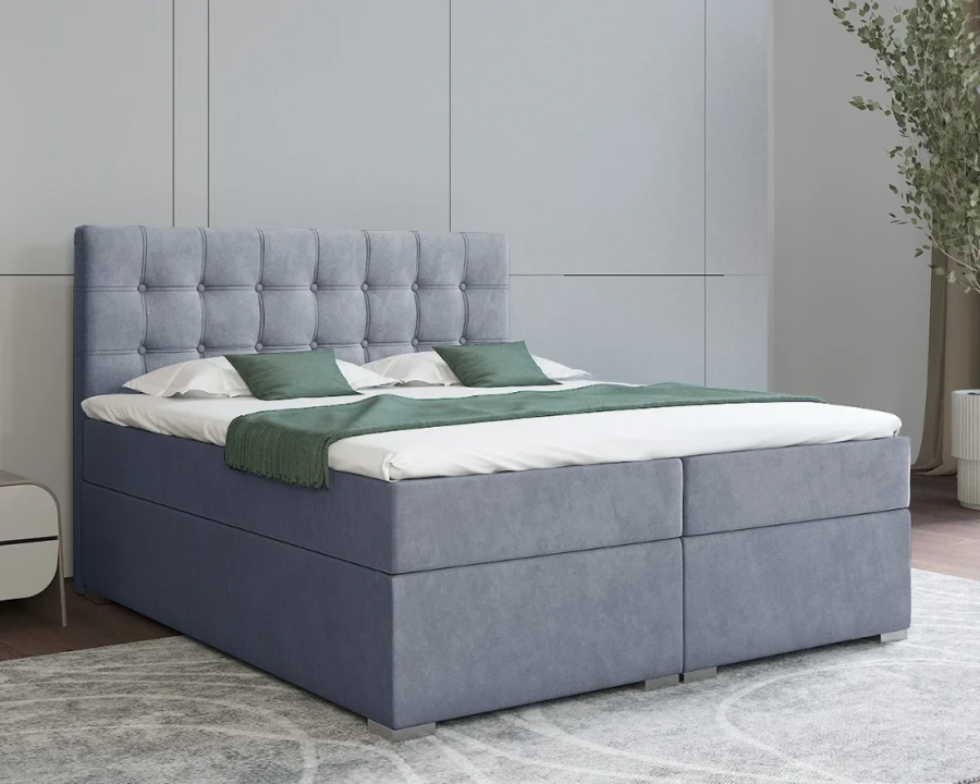 Hellblaues Boxspringbett mit dekorativ abgestepptem Kopfteil.