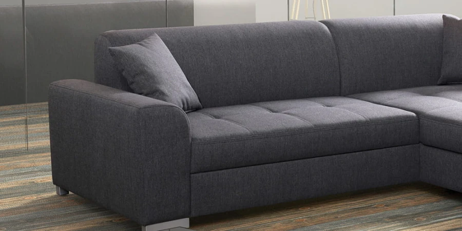 Nahaufnahme der Armlehne und des grauen Webstoffs eines modernen Sofas.