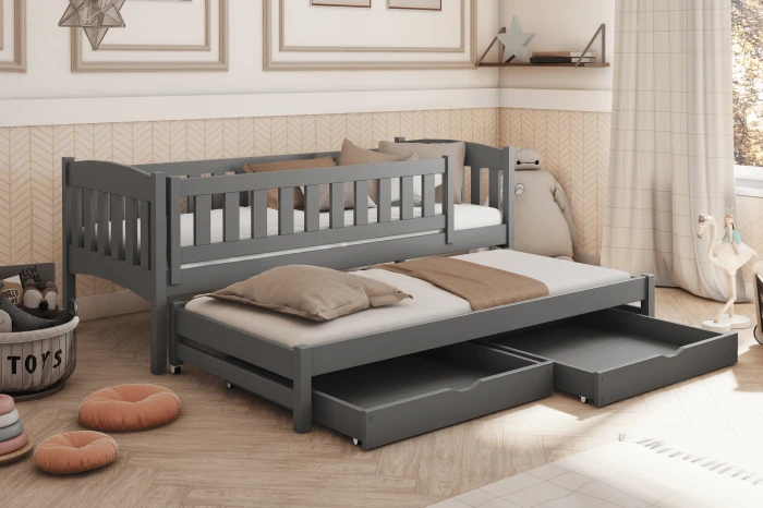 Graues Kinderbett mit Ausziehfunktion und zwei Schubladen im gemütlich eingerichteten Kinderzimmer.