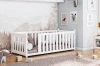 Weißes Gitterbett für Babys mit hohem Seitengitter im skandinavischen Stil.