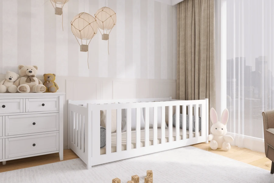 Klassisches weißes Babybett neben Kommode im hell gestalteten Kinderzimmer.