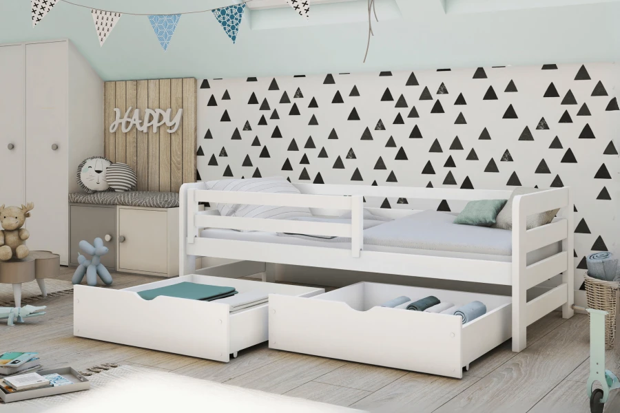Modernes Kinderzimmer mit weißem Kinderbett und ausgezogenen Stauraumschubladen vor einer Dreieck-Tapete.