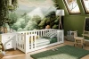 Weißes Holzbett im liebevoll eingerichteten Kinderzimmer mit Waldmotiv.