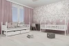 Ingerichte kinderkamer voor meisjes met witte bedden en eenhoornbehang.