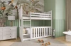 Wit stapelbed in de kinderkamer met babybed onderaan, ladekast en jungle-wanddecoratie.