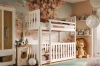 Wit stapelbed in de speelse kinderkamer met luchtballon-behang en grote pluche leeuw.