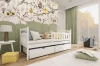 Weißes Jugendbett mit Stauraum in einem Kinderzimmer mit Eulentapete und grüner Wand.