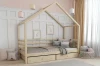 Kinder-Hausbett aus Naturholz mit zwei Schubladen und gemütlicher Dekoration.