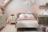 Modernes Kinderzimmer in Rosa und Weiß mit gemütlichem Bett und Schreibtisch.
