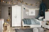 Helles Kinderzimmer mit Kleiderschrank, Bett mit blauem Betthimmel und Dekoration.