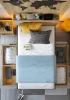 Modernes Jugendbett mit blauer Decke, Weltkarte und praktischen Bettkasten-Schubladen.