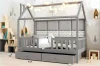 Dekoriertes Hausbett für Kinder in Grau mit Lichterkette, Wandpolstern und hellen Holzmöbeln.