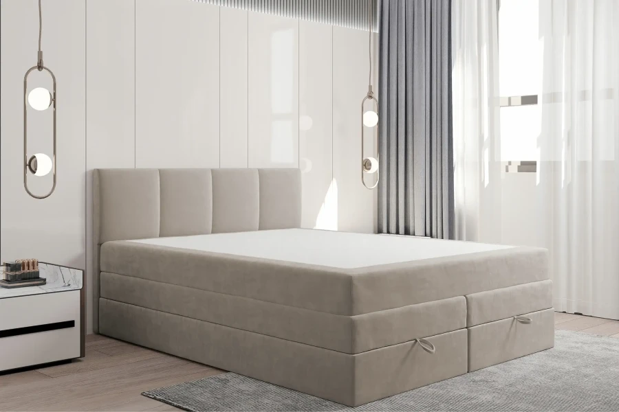 Beiges Boxspringbett mit Bettkasten ohne Bettwäsche in einem hellen Schlafzimmer.