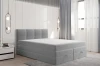 Modernes hellgraues Boxspringbett ohne Bettzeug in hellem Schlafzimmer-Design.