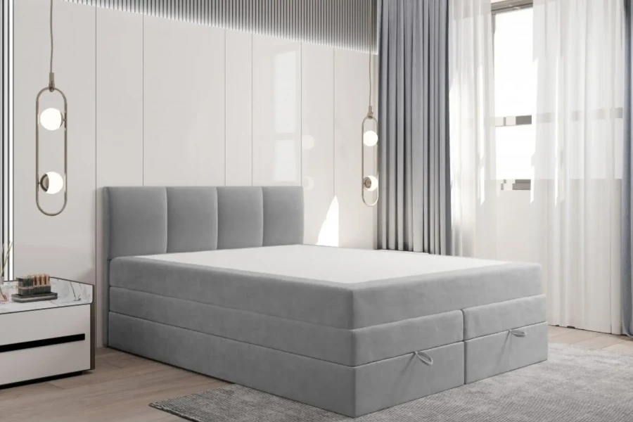 Modernes hellgraues Boxspringbett ohne Bettzeug in hellem Schlafzimmer-Design.