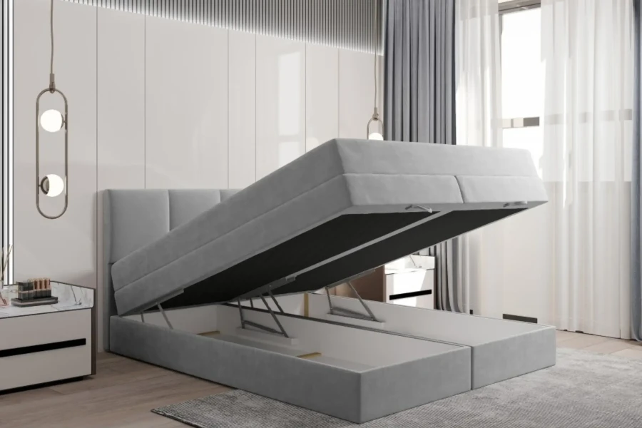 Funktionelles hellgraues Boxspringbett mit aufgeklapptem Bettkasten für Stauraum.