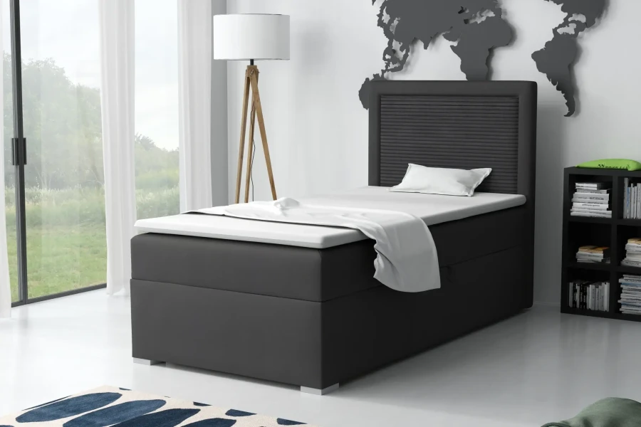 Stilvolles schwarzes Boxspringbett in hellem Raum mit Bücherregal und Fenster.
