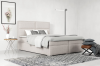Modernes Boxspringbett in Beige im hellen Schlafzimmer mit Teppich und Deko.