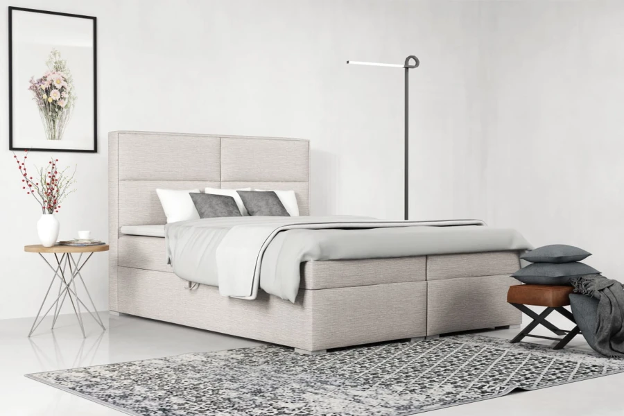 Modernes Boxspringbett in Beige im hellen Schlafzimmer mit Teppich und Deko.