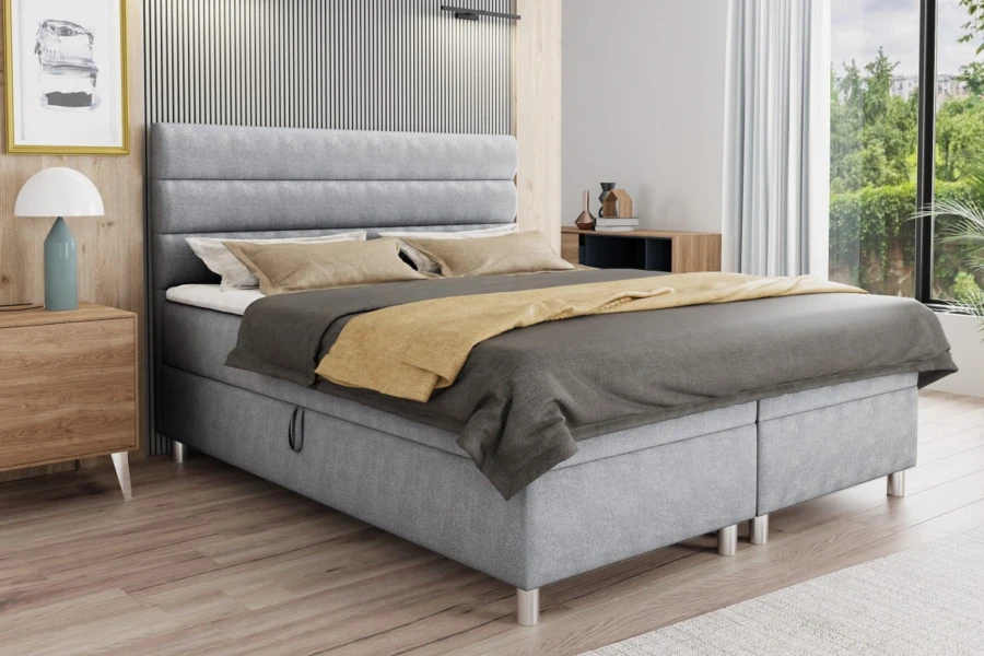 Stilvolles graues Boxspringbett in modern eingerichtetem Schlafzimmer.