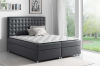 Modernes anthrazitfarbenes Boxspringbett mit gestepptem Kopfteil in hellem Schlafzimmer.