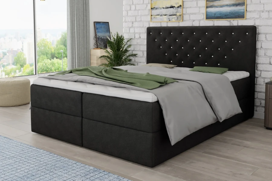 Boxspringbett in Anthrazit mit dekorativem Kopfteil und grüner Decke im Schlafzimmer.