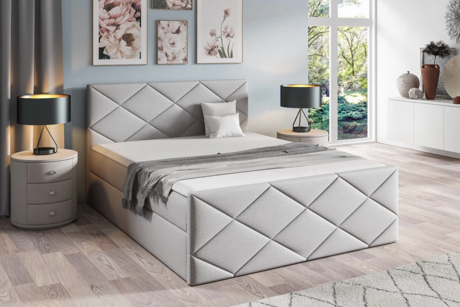 Hellgraues Boxspringbett mit Rautenmuster-Kopfteil und stilvoller Einrichtung.