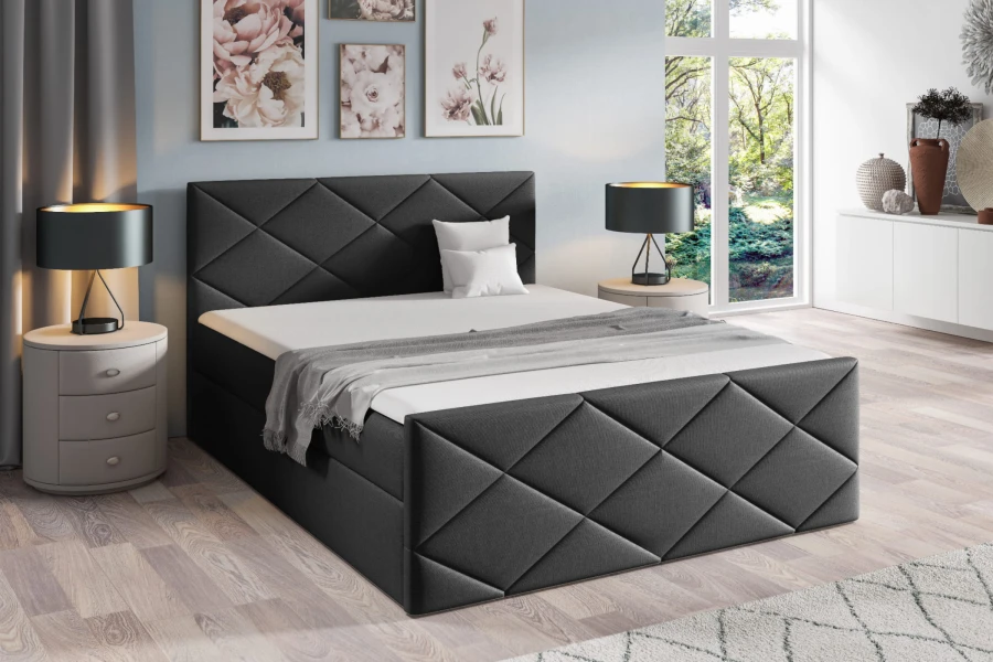 Anthrazitfarbenes Boxspringbett mit gestepptem Kopfteil und moderner Deko.