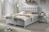 Modernes hellgraues Boxspringbett mit Knopfheftung im hellen Schlafzimmer