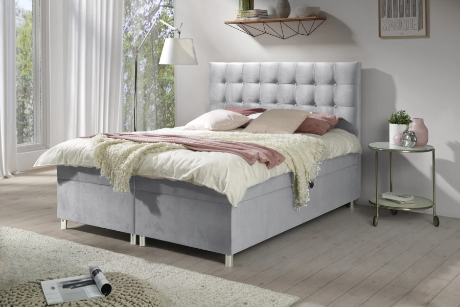 Modernes hellgraues Boxspringbett mit Knopfheftung im hellen Schlafzimmer